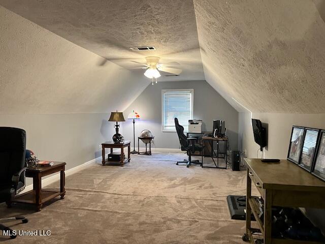 office space with a textured ceiling, ceiling fan, lofted ceiling, and carpet flooring