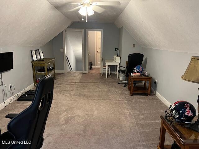 carpeted office space featuring lofted ceiling, a textured ceiling, and ceiling fan