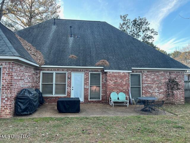 back of property featuring a yard and a patio area