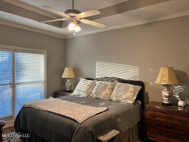 bedroom featuring ceiling fan, ornamental molding, and wood-type flooring