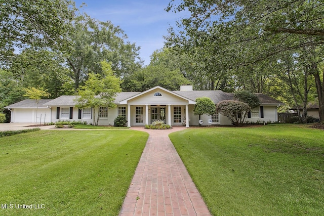 view of front of property with a porch, driveway, a chimney, and a front yard
