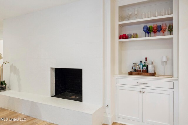 bar featuring white cabinets and light wood-type flooring