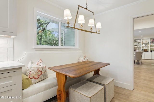 dining area featuring ornamental molding, baseboards, and light wood-type flooring