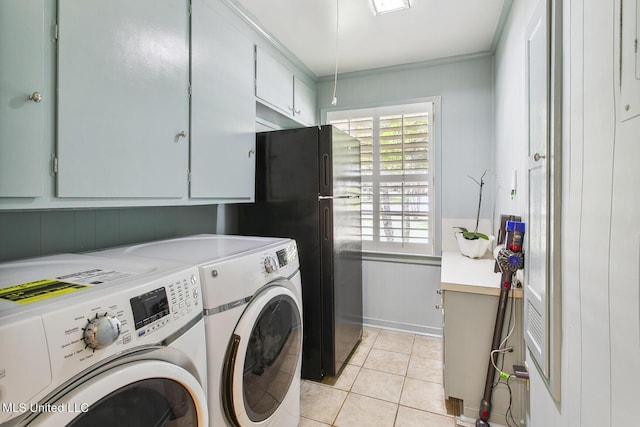 laundry room featuring washing machine and clothes dryer, ornamental molding, cabinet space, and light tile patterned floors