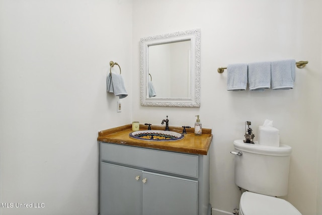 half bathroom featuring toilet and vanity