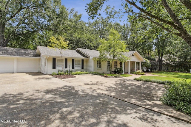 single story home with concrete driveway, a porch, an attached garage, and a front yard