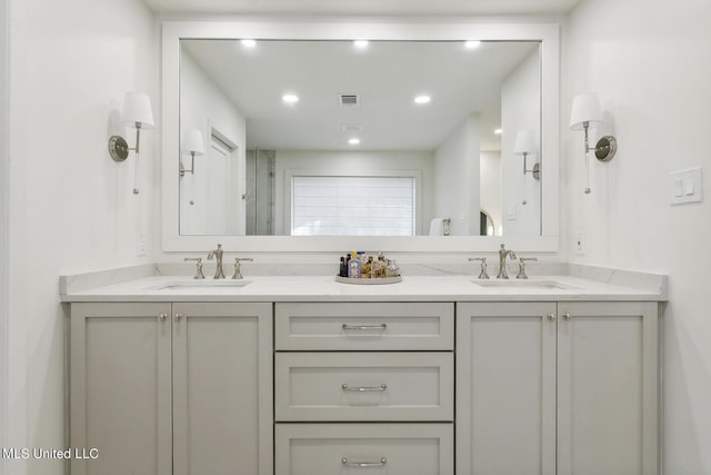 full bath featuring a sink, double vanity, and a stall shower