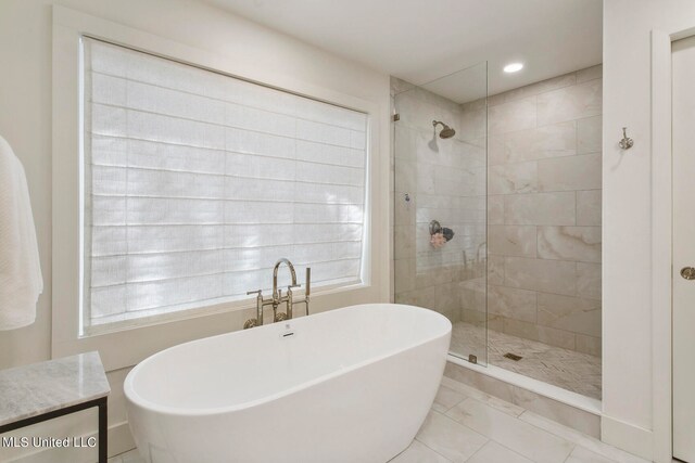 bathroom with vanity, separate shower and tub, a healthy amount of sunlight, and tile patterned floors