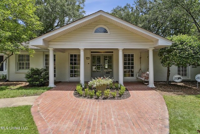 view of front facade with french doors and brick siding