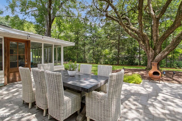 view of patio featuring a sunroom