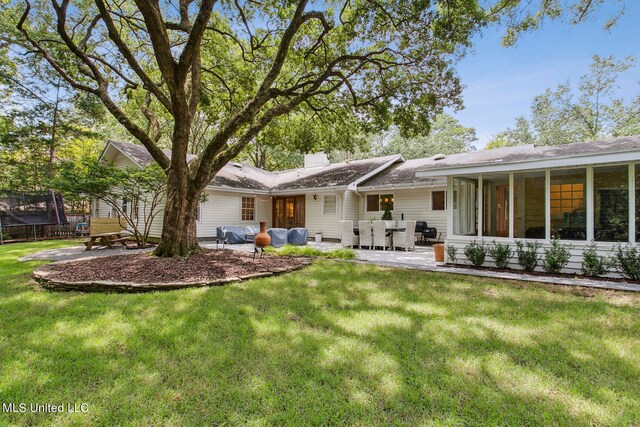 back of house with a patio area, a lawn, and a sunroom