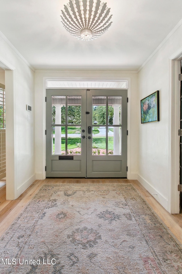 entryway with french doors, hardwood / wood-style floors, and crown molding