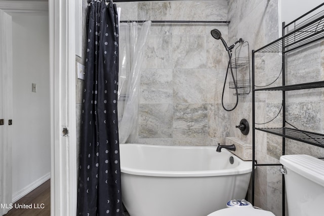 full bath featuring baseboards, toilet, wood finished floors, and shower / bath combination with curtain