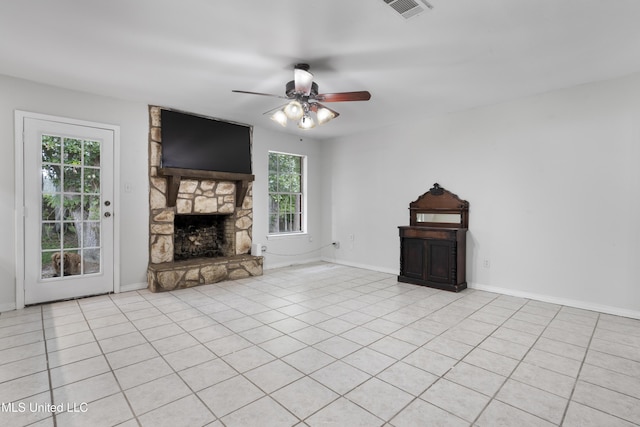 unfurnished living room with a ceiling fan, visible vents, a wealth of natural light, and a fireplace