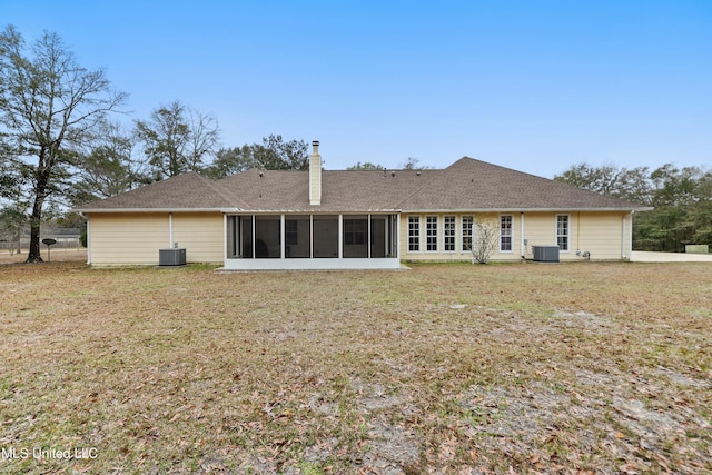 back of house featuring central AC unit, a lawn, and a sunroom