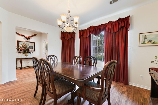 dining room featuring hardwood / wood-style floors and a notable chandelier