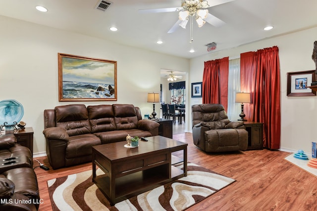 living room with light hardwood / wood-style flooring and ceiling fan