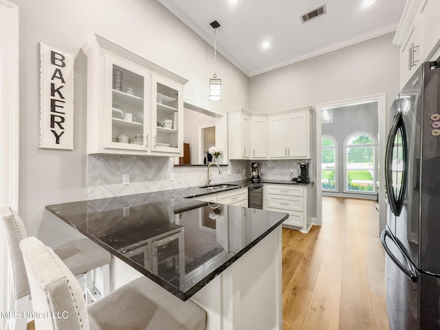 66 Auburn Pl, Hattiesburg, MS 39402 - kitchen with freestanding refrigerator, a sink, crown molding, a kitchen bar, and hanging light fixtures