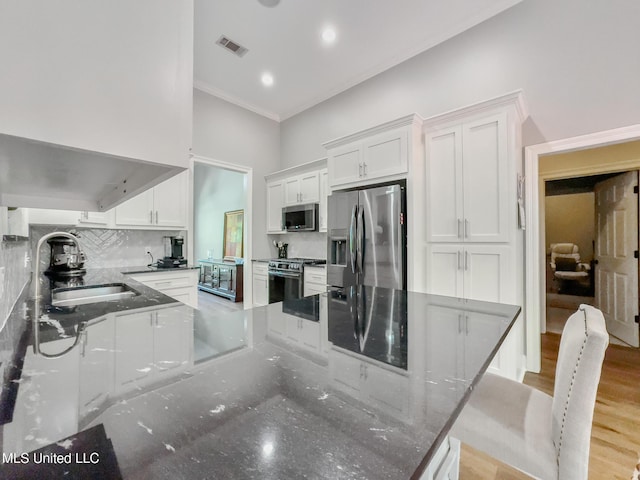 66 Auburn Pl, Hattiesburg, MS 39402 - kitchen featuring appliances with stainless steel finishes, a sink, white cabinets, tasteful backsplash, and crown molding