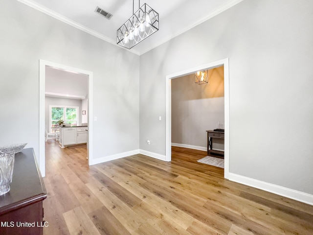 66 Auburn Pl, Hattiesburg, MS 39402 - unfurnished dining area with a chandelier, ornamental molding, light wood-style floors, and baseboards