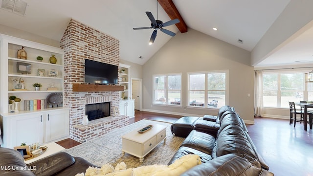 living room featuring built in shelves, vaulted ceiling with beams, ceiling fan, light wood-type flooring, and a brick fireplace