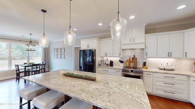 kitchen with white cabinetry, electric range, black refrigerator, and decorative light fixtures