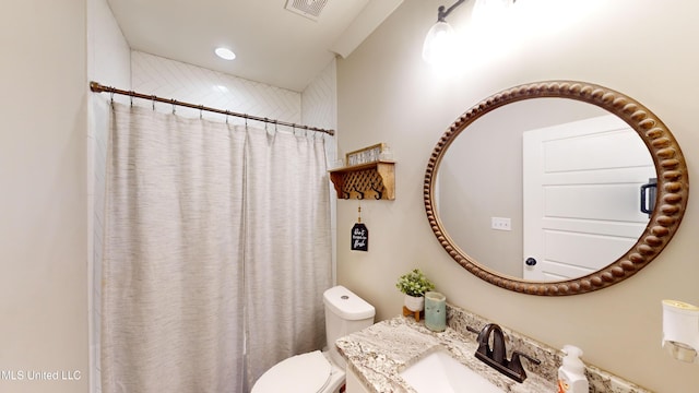 bathroom featuring toilet, a shower with shower curtain, and vanity