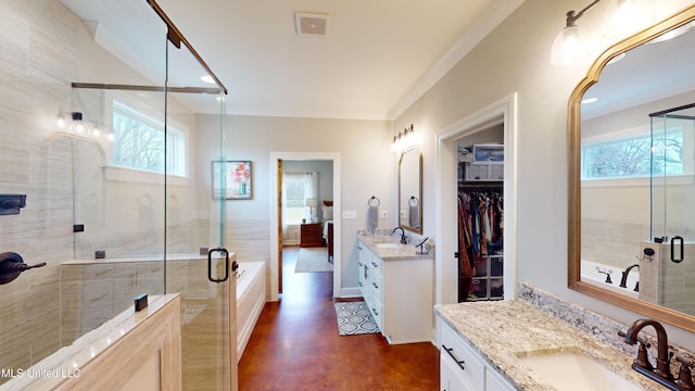 bathroom featuring a healthy amount of sunlight, a shower with shower door, and vanity