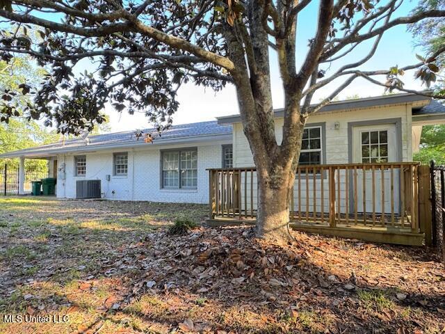 back of house featuring a wooden deck, cooling unit, and brick siding