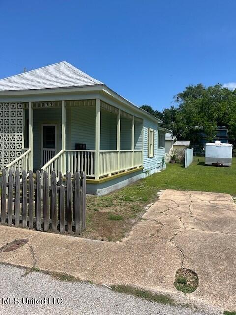128 Thomas St, Biloxi, MS 39530 - view of side of property with covered porch and roof with shingles