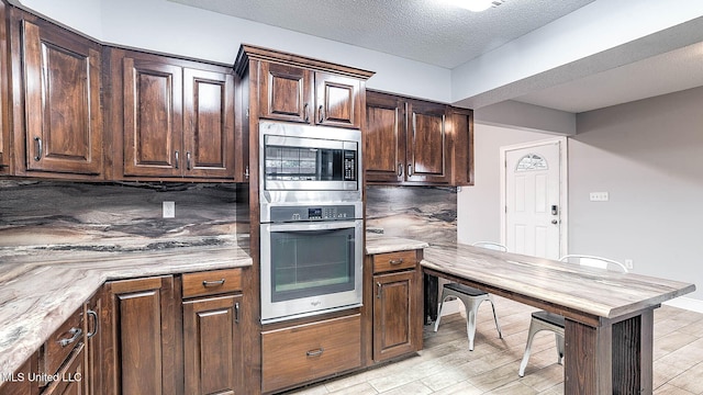 8 Skeeter Ln, Carriere, MS 39426 - kitchen with appliances with stainless steel finishes, tasteful backsplash, dark brown cabinets, a textured ceiling, and baseboards