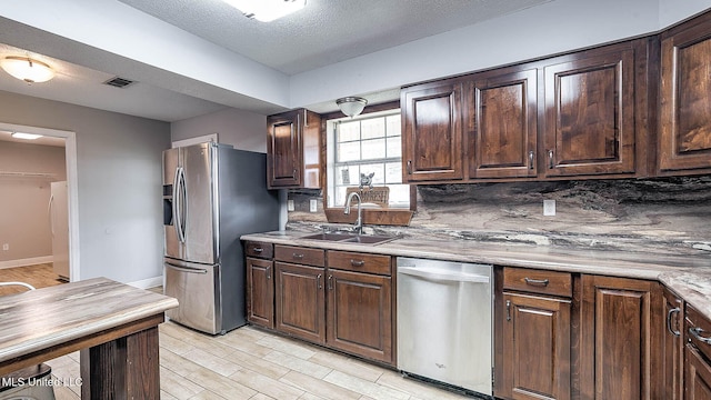 8 Skeeter Ln, Carriere, MS 39426 - kitchen with stainless steel appliances, a sink, light countertops, light wood-type flooring, and dark brown cabinetry