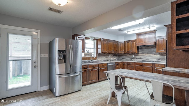 8 Skeeter Ln, Carriere, MS 39426 - kitchen with stainless steel fridge with ice dispenser, a sink, tasteful backsplash, light countertops, and light wood-style flooring