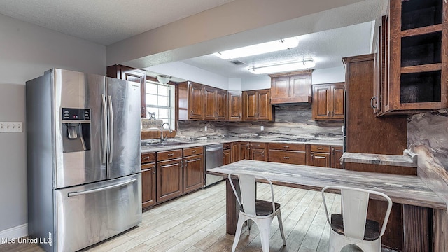 8 Skeeter Ln, Carriere, MS 39426 - kitchen with stainless steel appliances, a sink, a textured ceiling, tasteful backsplash, and light wood-style floors