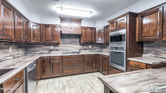 8 Skeeter Ln, Carriere, MS 39426 - kitchen with appliances with stainless steel finishes, a textured ceiling, tasteful backsplash, light wood-style floors, and dark brown cabinets