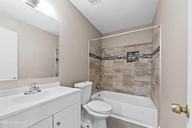 full bathroom featuring tiled shower / bath combo, vanity, and toilet