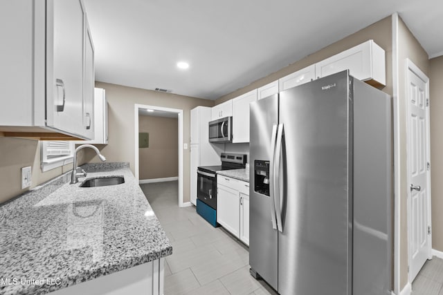 kitchen featuring sink, stainless steel appliances, white cabinets, and light stone countertops