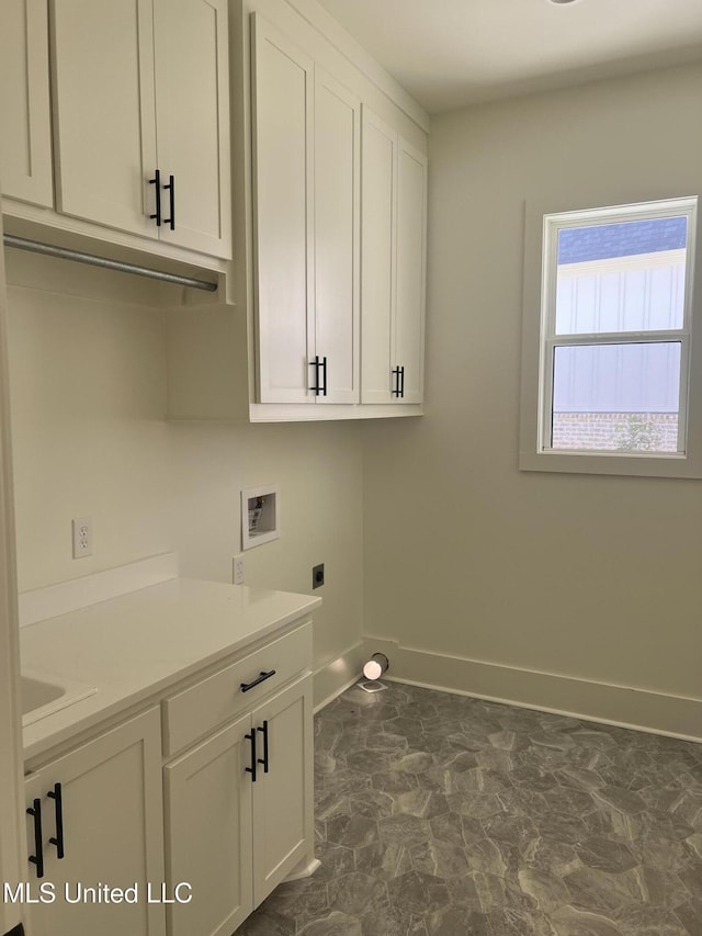 washroom with cabinet space, hookup for a washing machine, hookup for an electric dryer, and baseboards