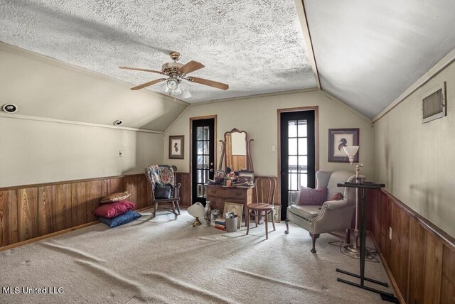 sitting room featuring a textured ceiling, carpet, and vaulted ceiling