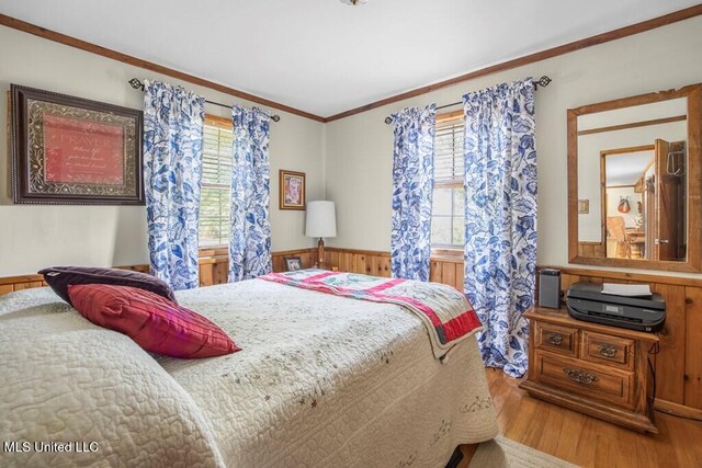 bedroom with wood walls, ornamental molding, and hardwood / wood-style flooring