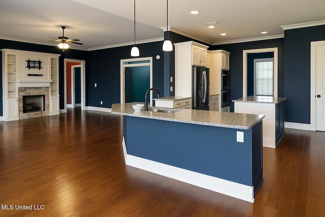 kitchen with a kitchen island, fridge, ornamental molding, and a sink