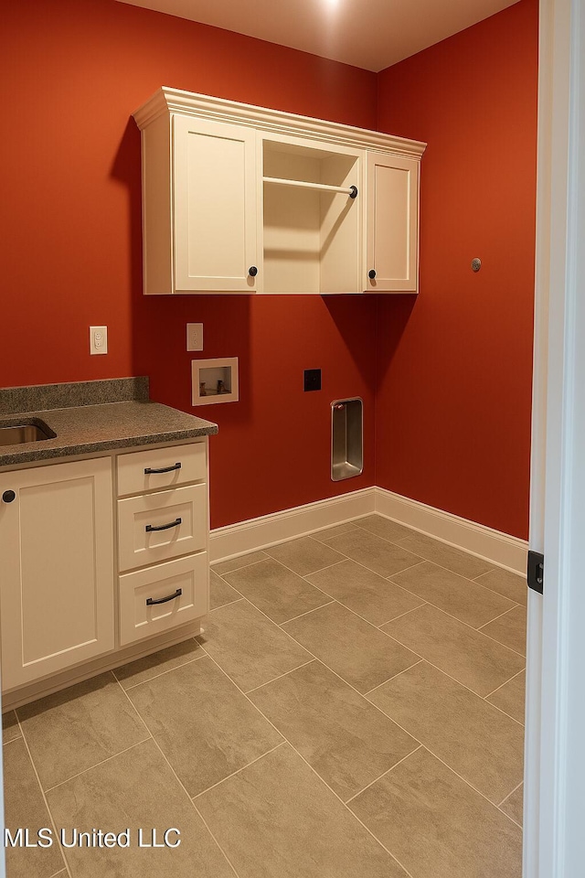 laundry room featuring baseboards, hookup for a washing machine, cabinet space, and light tile patterned flooring