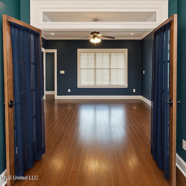 empty room with baseboards, ceiling fan, ornamental molding, and hardwood / wood-style flooring