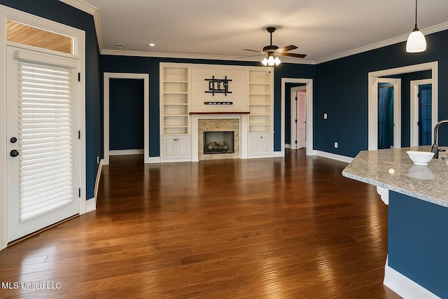 unfurnished living room with dark wood-style flooring, baseboards, ornamental molding, and ceiling fan