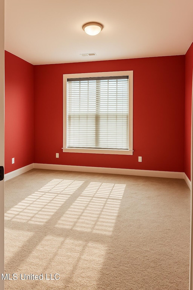 carpeted empty room with baseboards and visible vents
