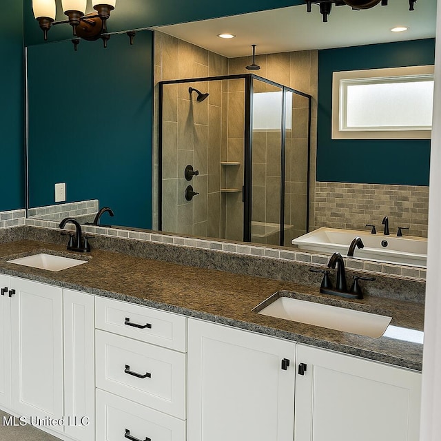 full bathroom featuring a garden tub, a sink, a stall shower, and double vanity