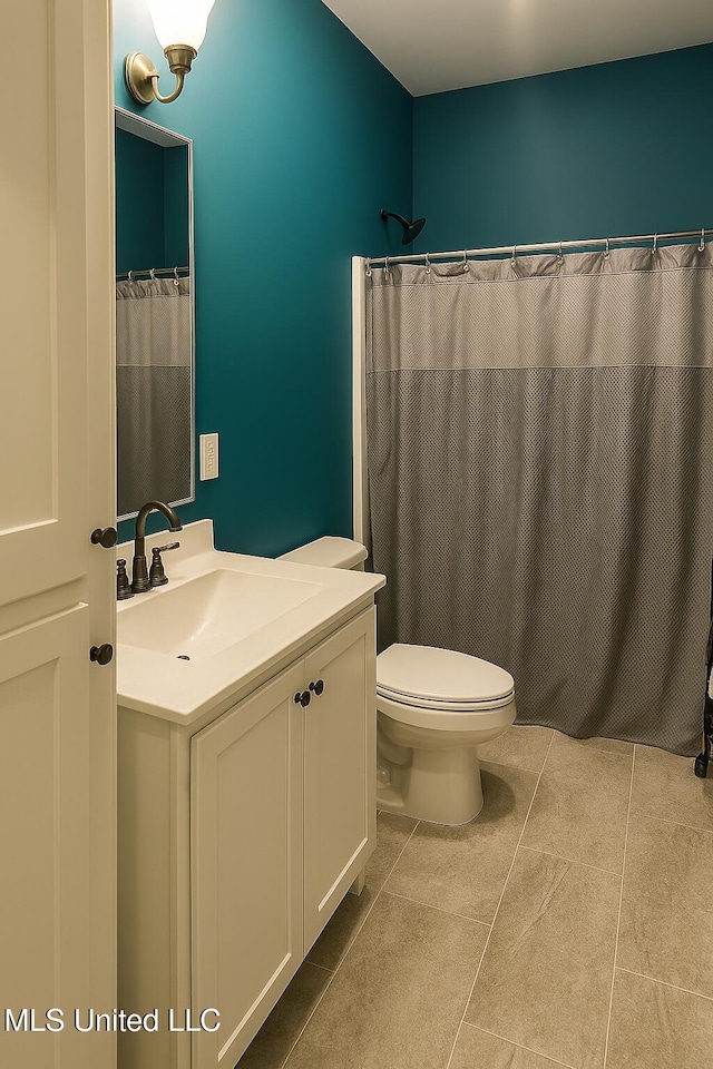 bathroom with toilet, curtained shower, tile patterned flooring, and vanity