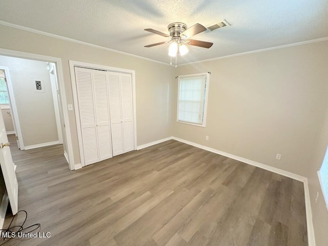 5448 Crepe Myrtle Dr, Jackson, MS 39206 - unfurnished bedroom featuring wood finished floors, a closet, baseboards, ornamental molding, and a textured ceiling