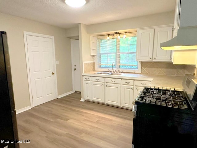 5448 Crepe Myrtle Dr, Jackson, MS 39206 - kitchen featuring gas range, a sink, white cabinets, extractor fan, and tasteful backsplash