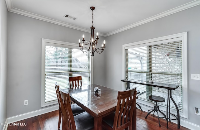 dining space with ornamental molding, dark hardwood / wood-style floors, and a chandelier